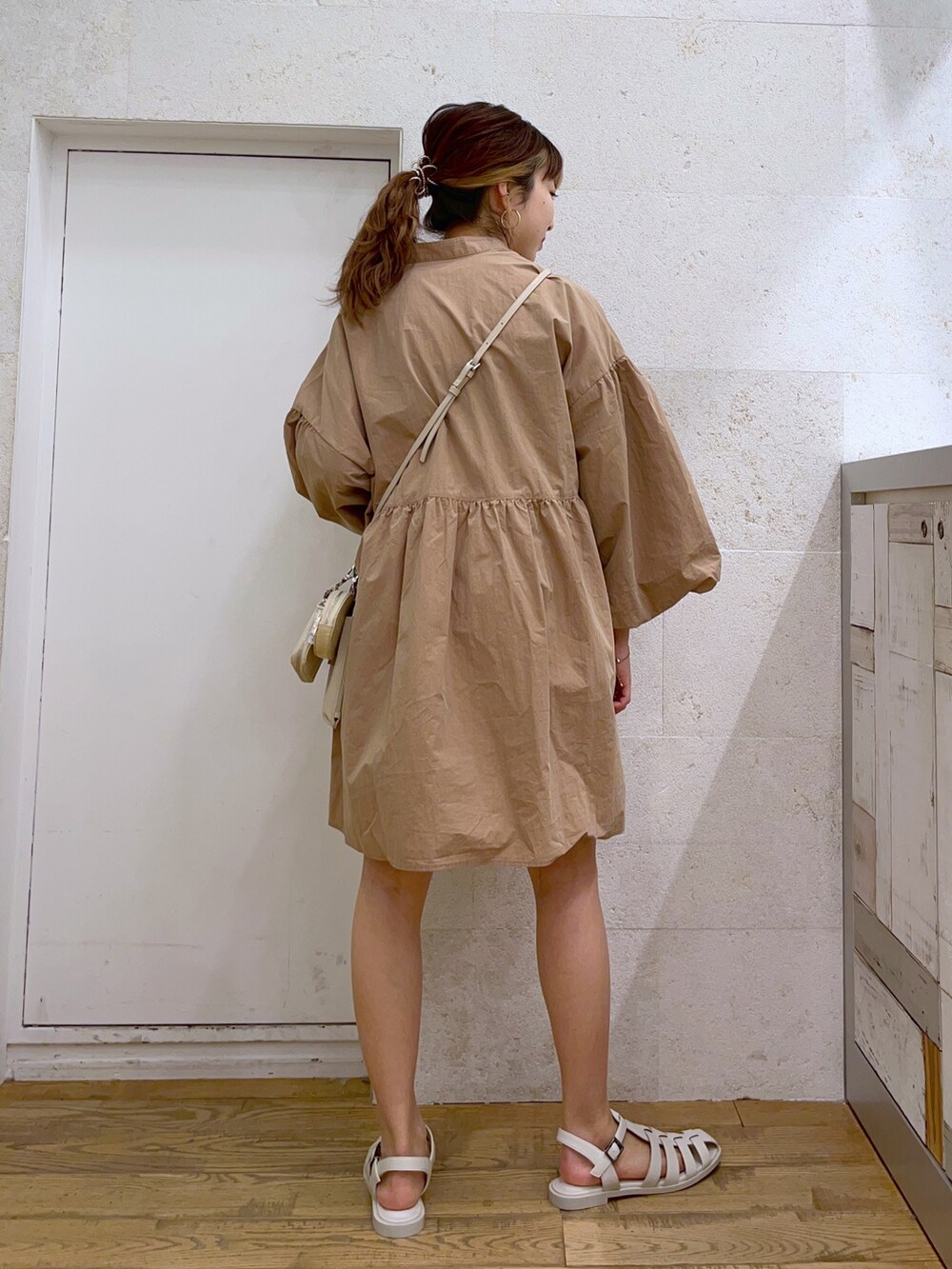 ベージュ系のトップス、ホワイト系のショルダーバッグ、ホワイト系のシューズを着用したレディースの春コーディネートの3枚目の写真