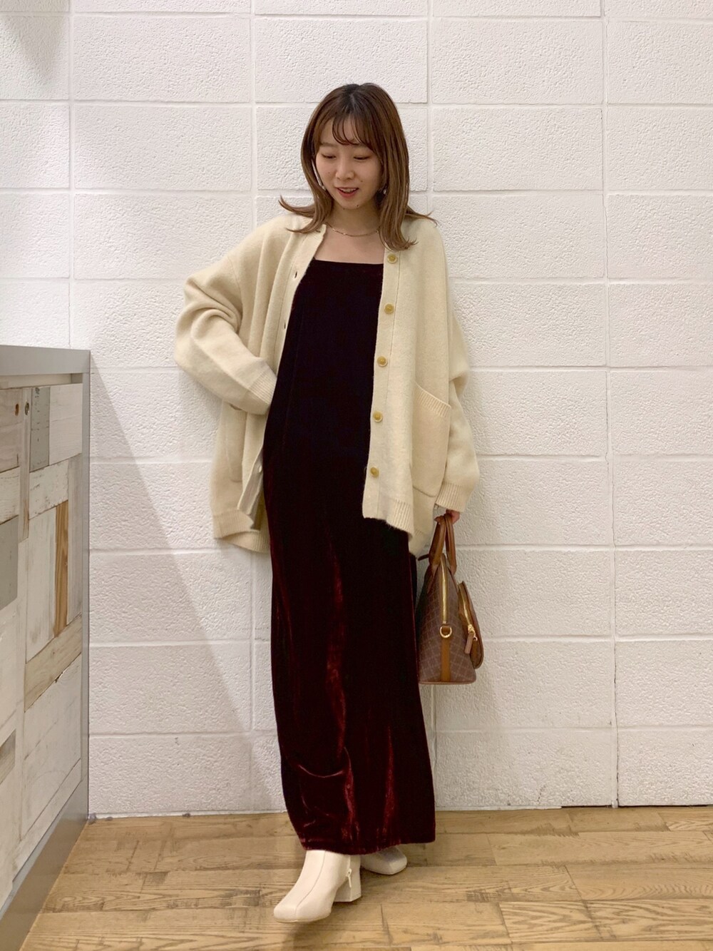 ホワイト系のトップス、レッド系のワンピース、ブラウン系のバッグを着用したレディースの秋コーディネートの3枚目の写真