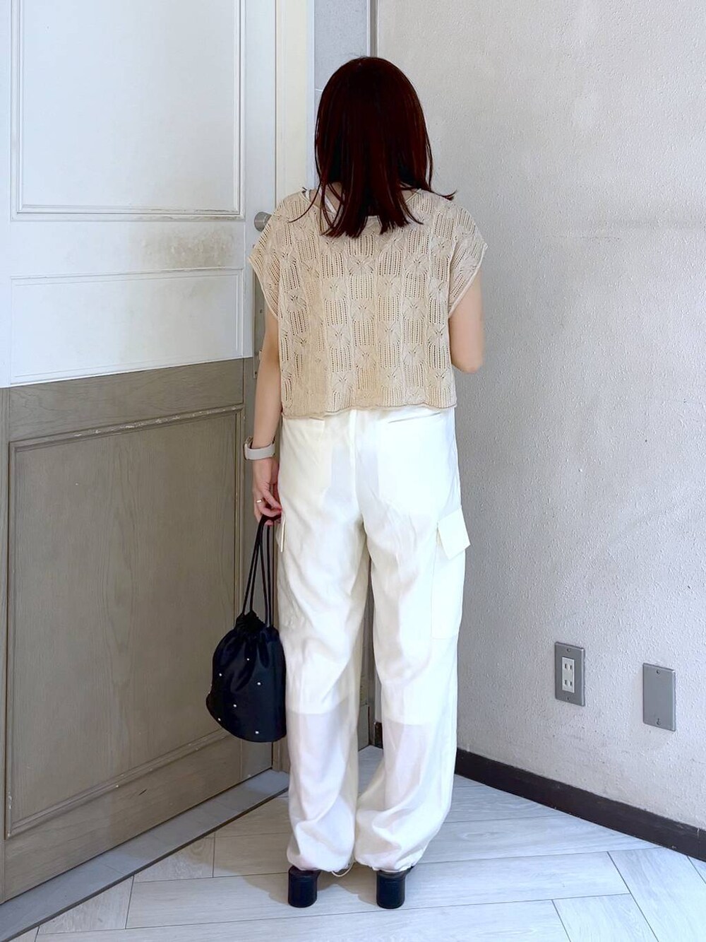 ホワイト系のカーゴパンツ、ブラック系のショルダーバッグ、ブラック系のサンダルを着用したレディースの夏コーディネートの5枚目の写真