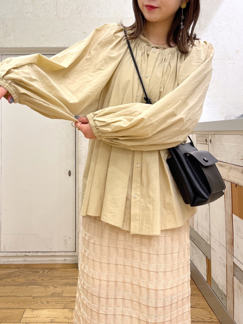 ブラウン系のシャツ/ブラウス、ホワイト系のバッグ、ブラック系のスカートを着用したレディースの春コーディネートの5枚目の写真