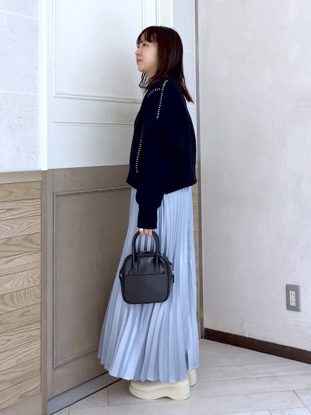 ブラック系のTシャツ/カットソー、ホワイト系のブーツ、ブラック系のボストンバッグを着用したレディースの冬コーディネートの3枚目の写真