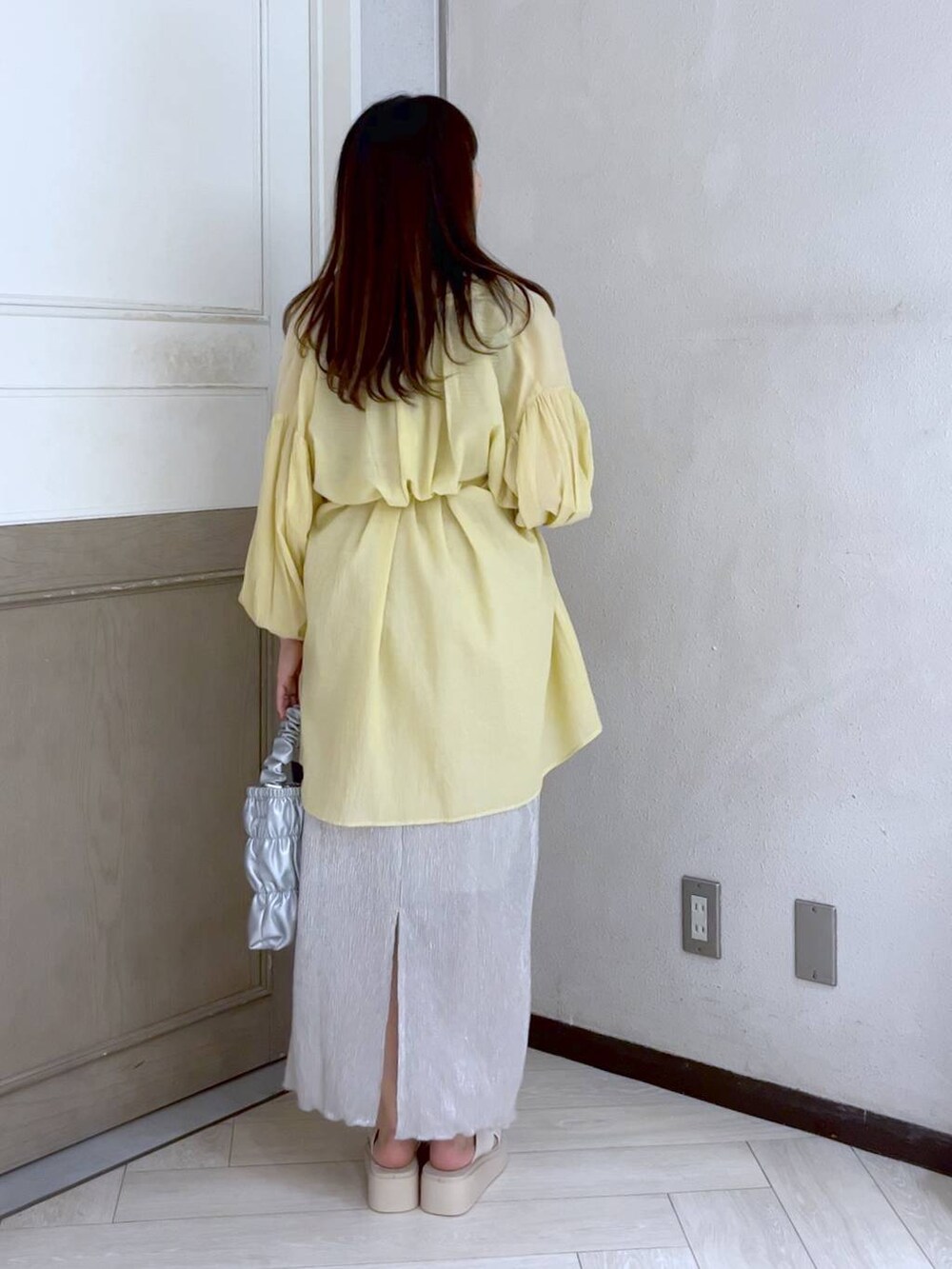 イエロー系のシャツ/ブラウス、ホワイト系のスカート、ホワイト系のサンダルを着用したレディースの夏コーディネートの4枚目の写真