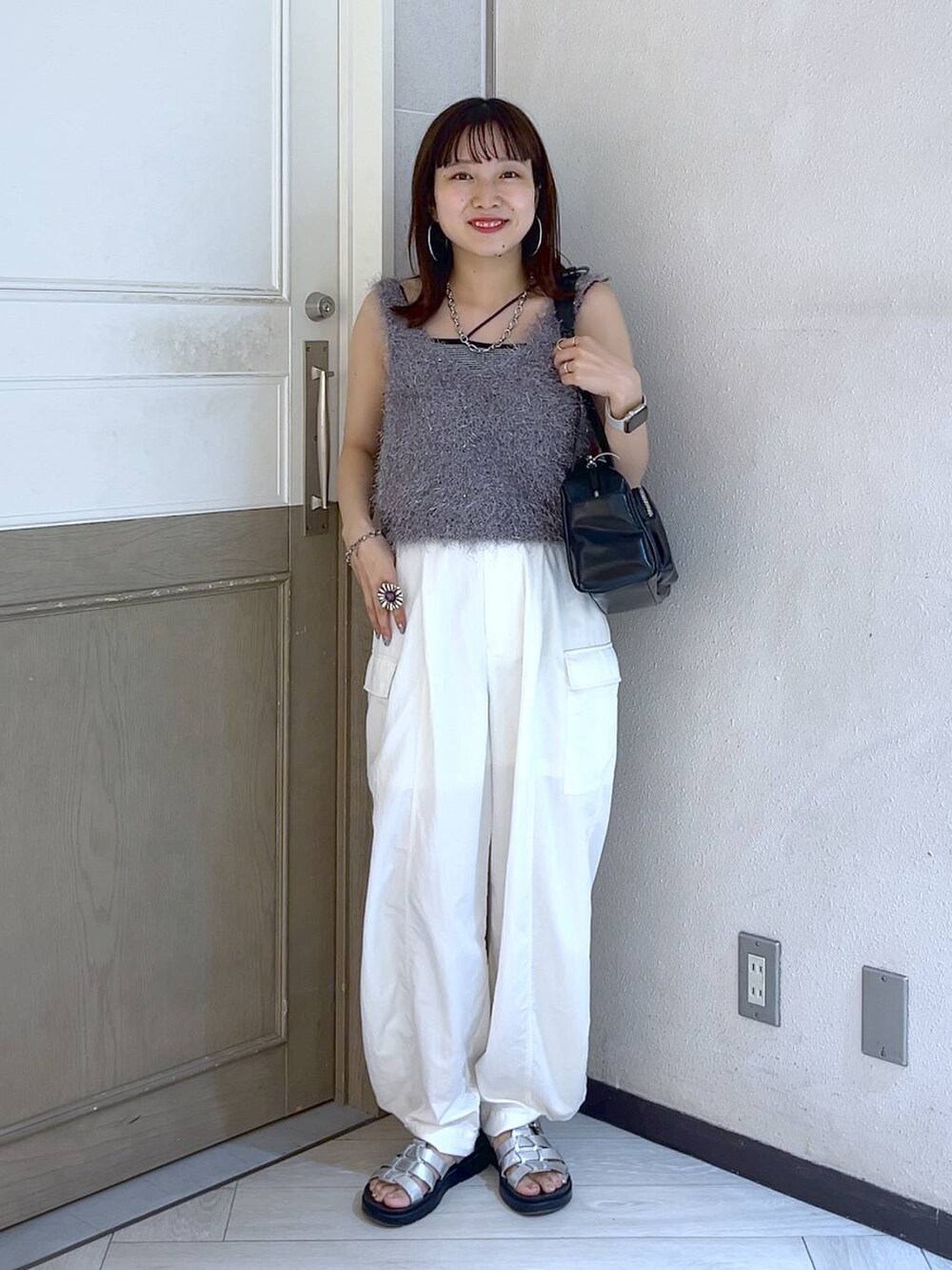 ホワイト系のカーゴパンツ、ブラック系のボストンバッグ、シルバー系のスニーカーを着用したレディースの夏コーディネートの2枚目の写真