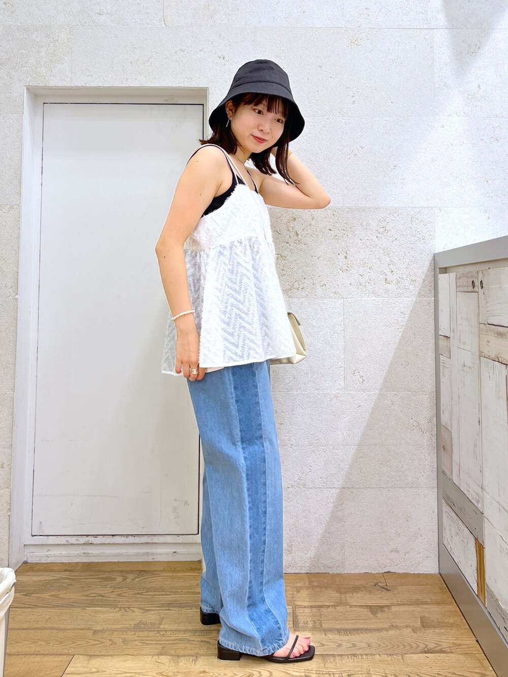 ブラック系のシューズ、ホワイト系のバッグ、ホワイト系のキャミソールを着用したレディースの夏コーディネートの3枚目の写真