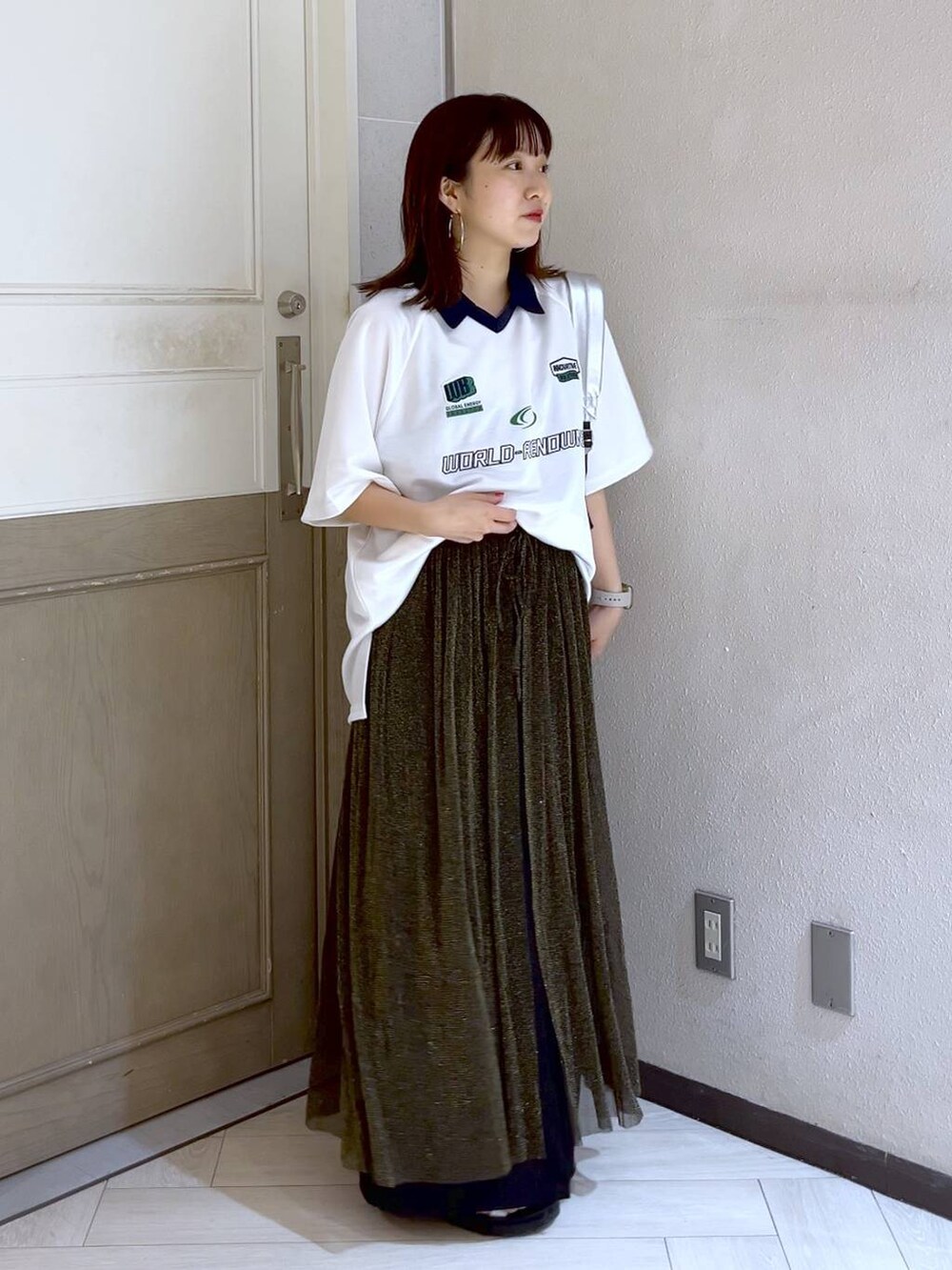 ブラック系のワンピース、シルバー系のショルダーバッグ、シルバー系のスニーカーを着用したレディースの夏コーディネートの2枚目の写真