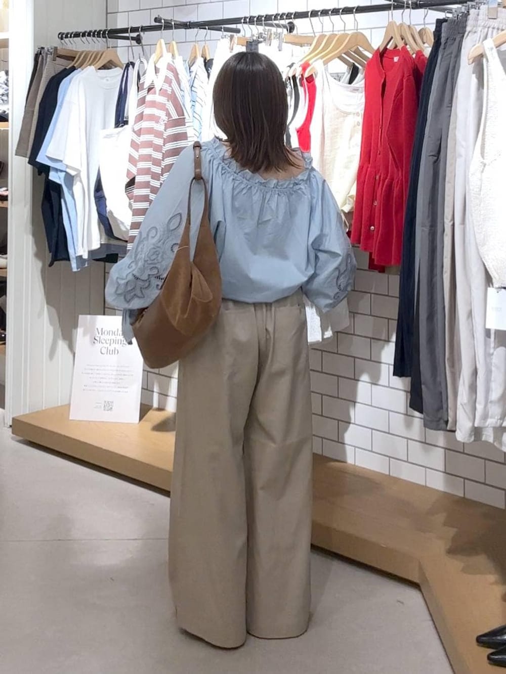 ブラック系のパンプス、ベージュ系のデニムパンツ、ブラウン系のショルダーバッグを着用したレディースの春コーディネートの3枚目の写真