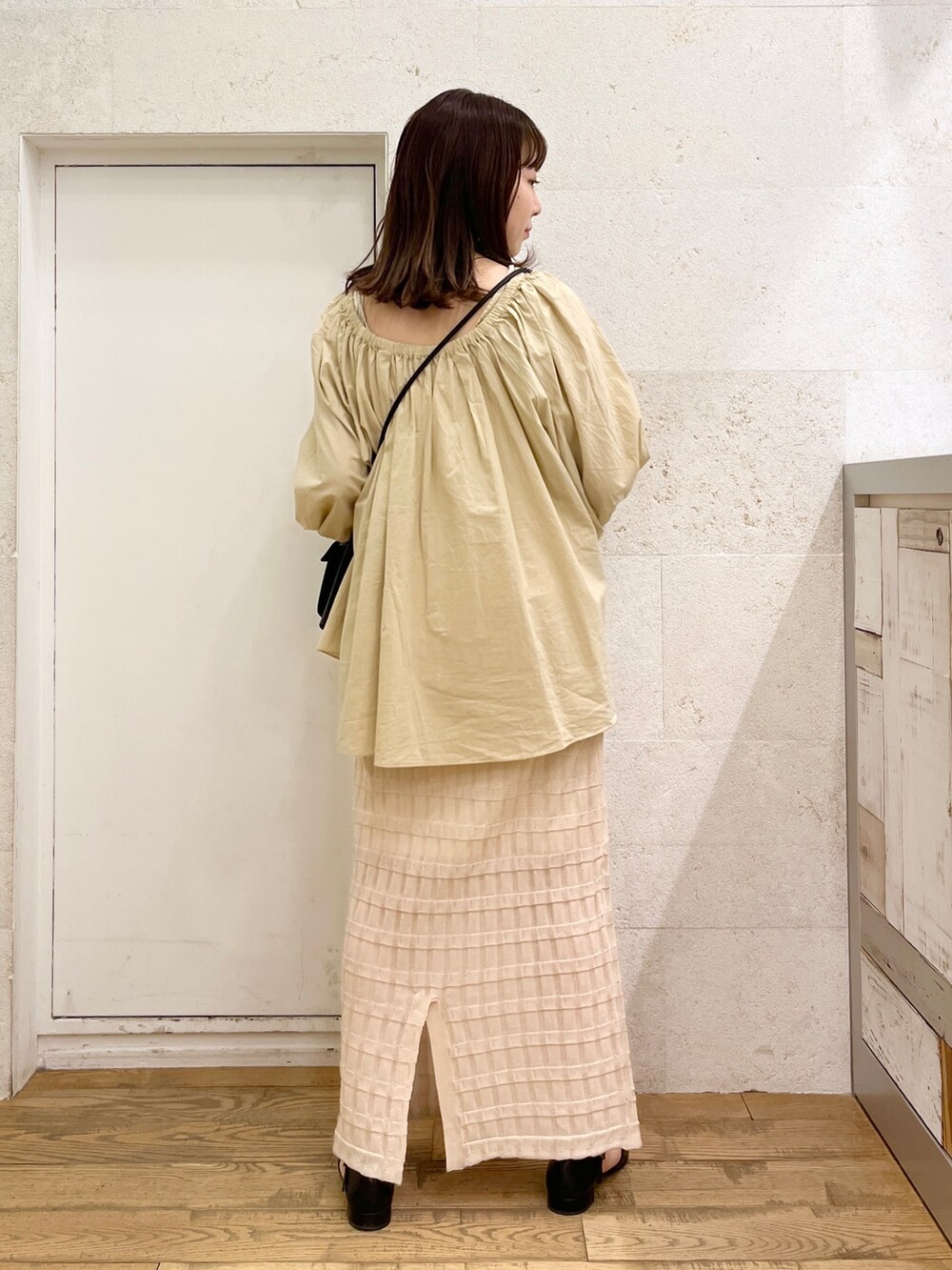 ブラウン系のシャツ/ブラウス、ホワイト系のバッグ、ブラック系のスカートを着用したレディースの春コーディネートの4枚目の写真