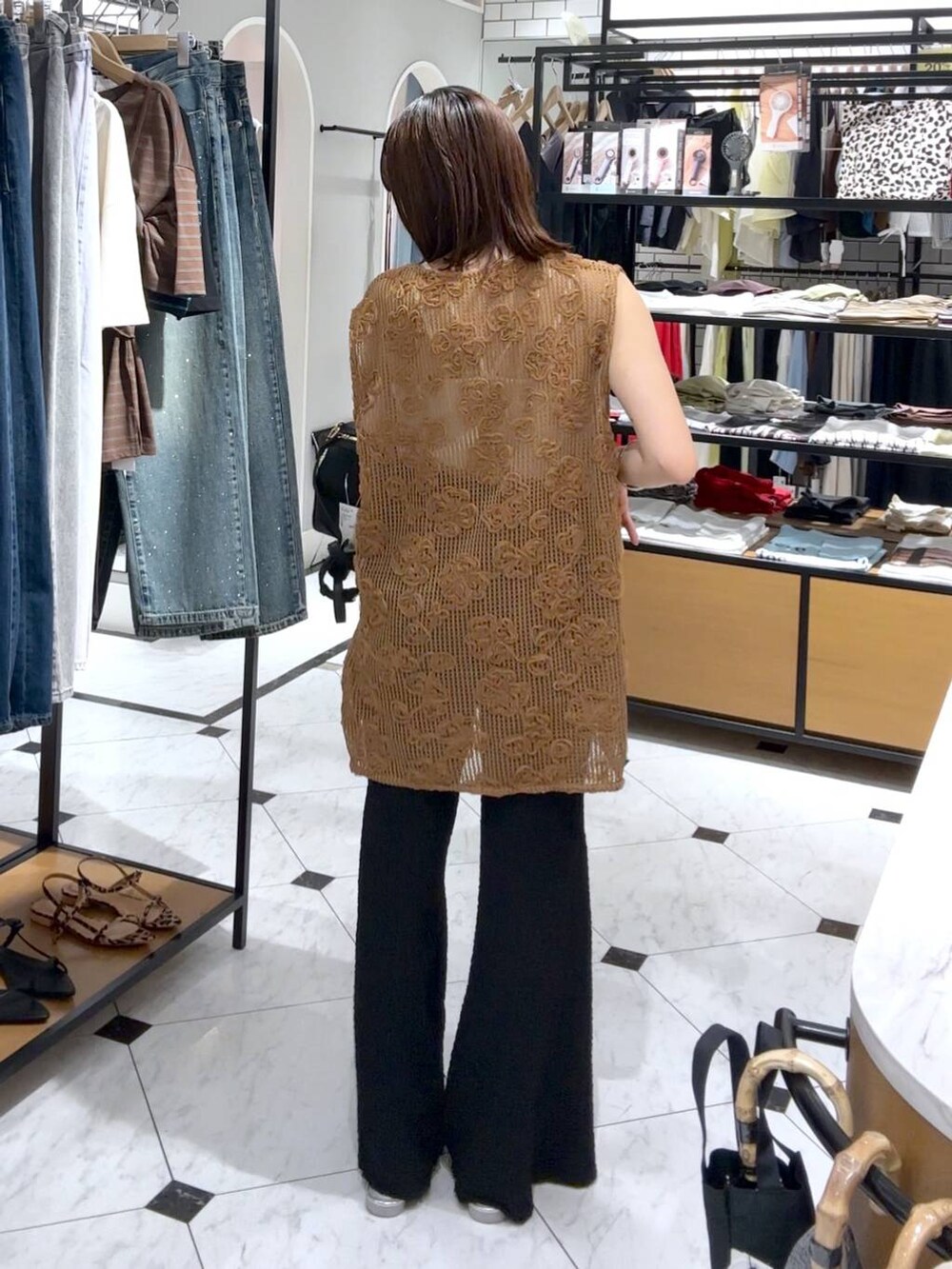 シルバー系のサンダル、ブラック系のその他パンツ、ブラウン系のベストを着用したレディースの夏コーディネートの3枚目の写真