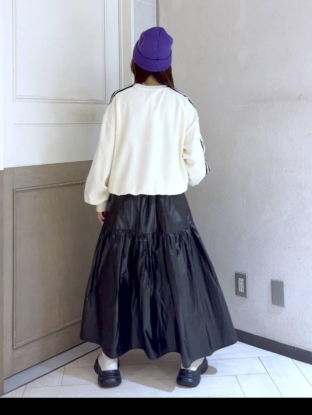 シルバー系のハンドバッグ、ホワイト系のスウェット、ホワイト系のブーツを着用したレディースの冬コーディネートの4枚目の写真