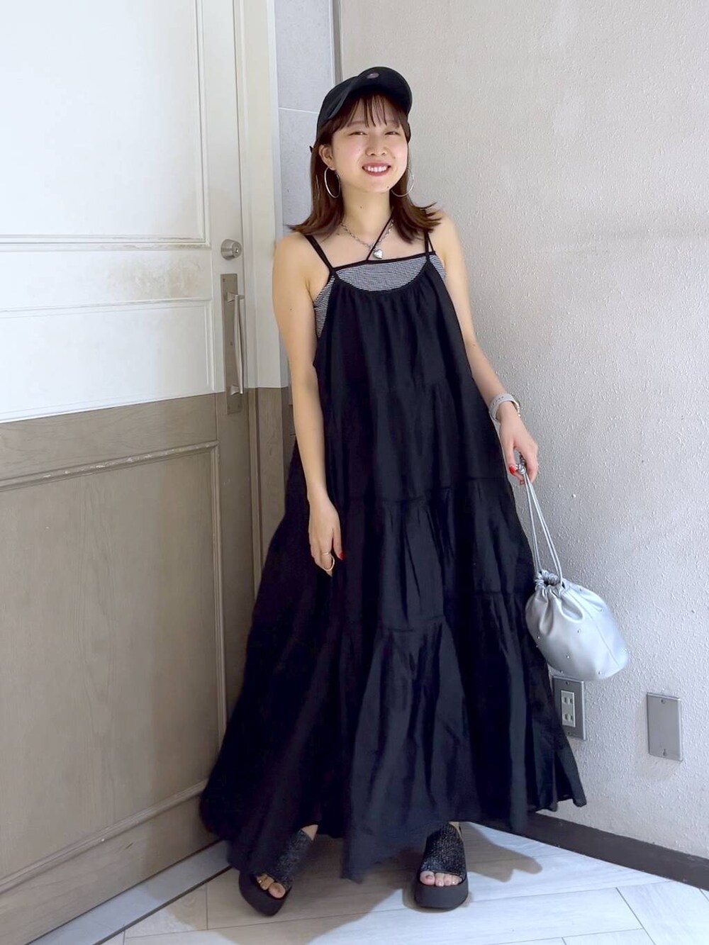 ブラック系のサンダル、シルバー系のショルダーバッグ、その他のキャミソールを着用したレディースの夏コーディネートの2枚目の写真
