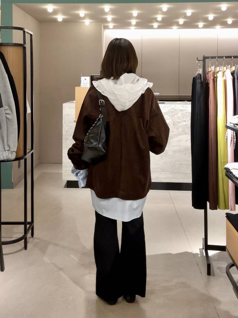 ホワイト系のシャツ/ブラウス、ブラック系のパンプス、ブラック系のショルダーバッグを着用したレディースの冬コーディネートの3枚目の写真