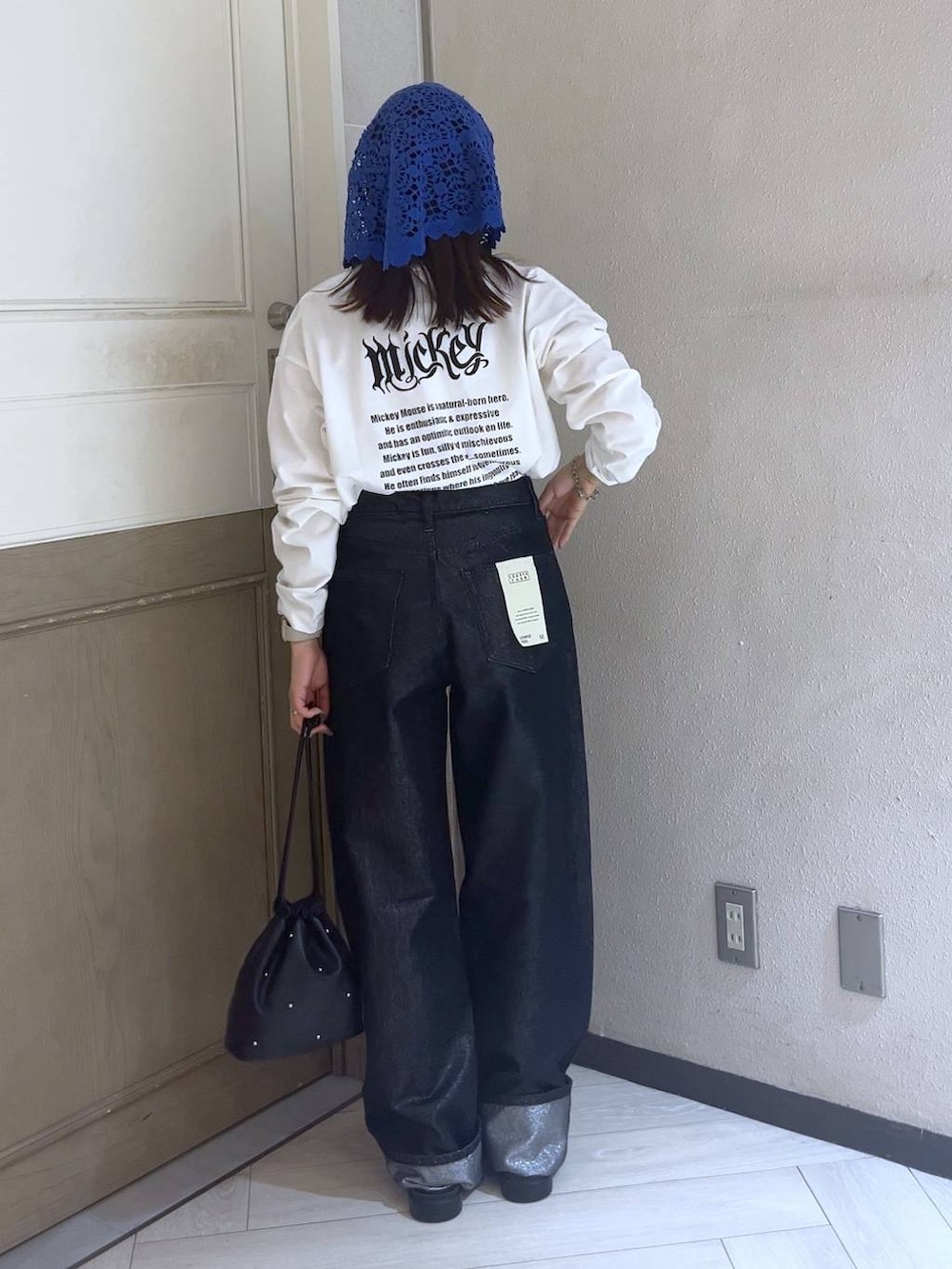 ブラック系のショルダーバッグ、シルバー系のスニーカー、グレー系のデニムパンツを着用したレディースの夏コーディネートの2枚目の写真