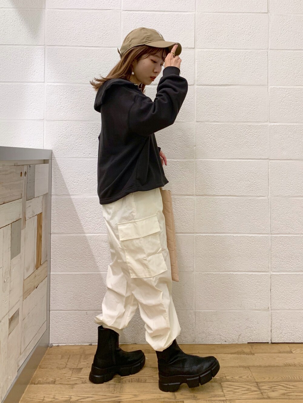 グレー系のトップス、ホワイト系のパンツ、ピンク系のショルダーバッグを着用したレディースの秋コーディネートの4枚目の写真