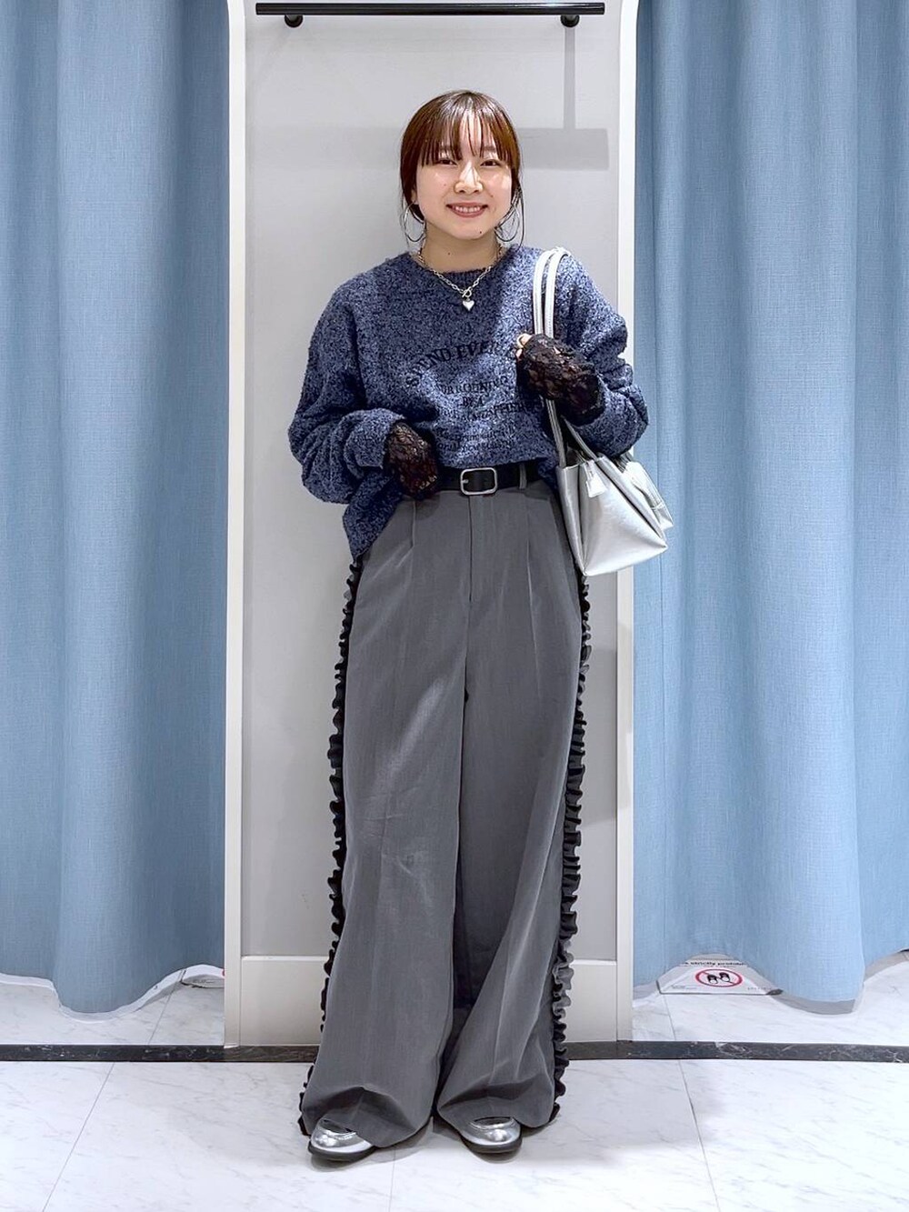 シルバー系のショルダーバッグ、シルバー系のローファー、ブルー系のニット/セーターを着用したレディースの冬コーディネートの2枚目の写真