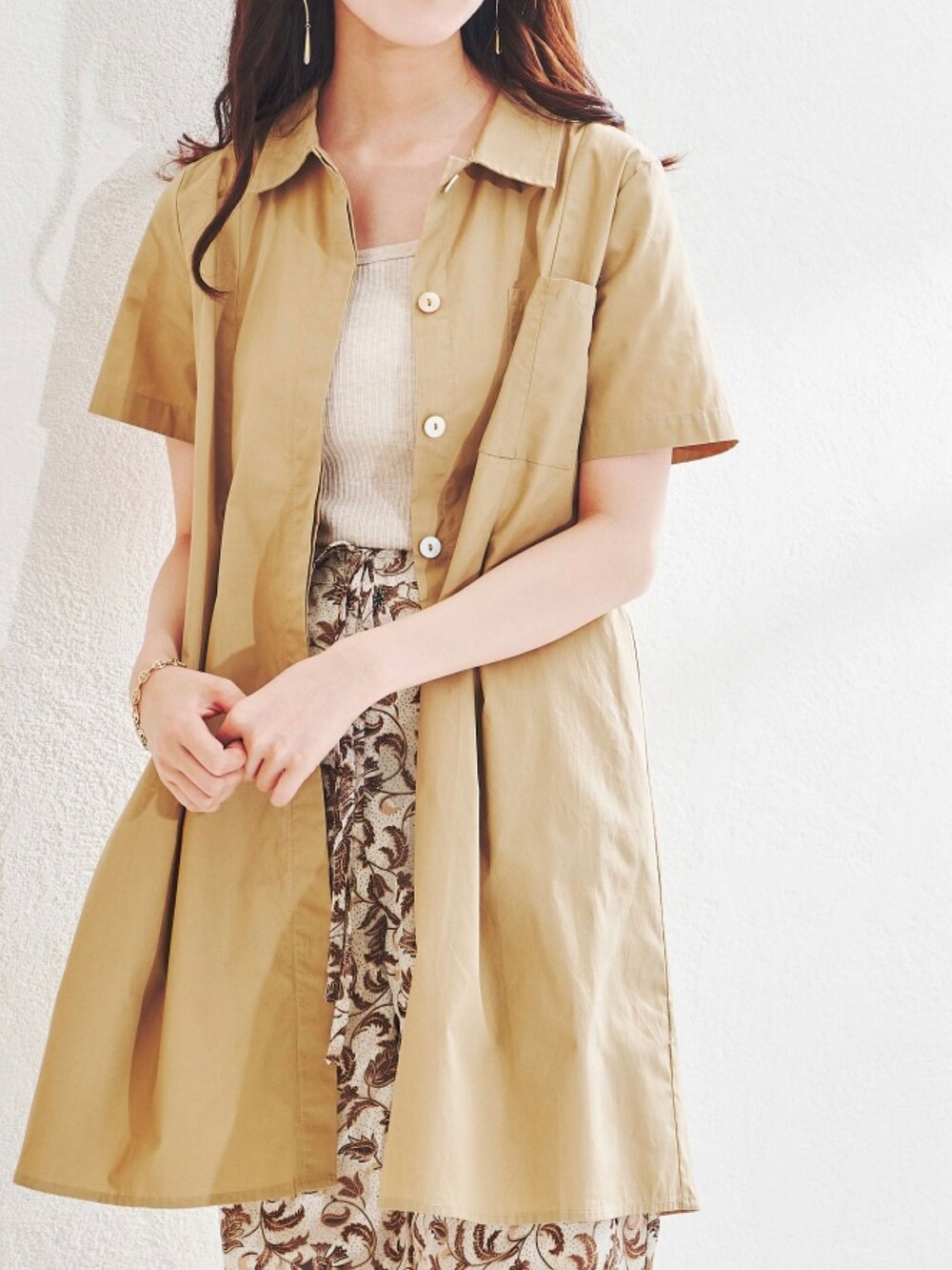 ホワイト系のシャツワンピースを着用したレディースの夏コーディネートの2枚目の写真