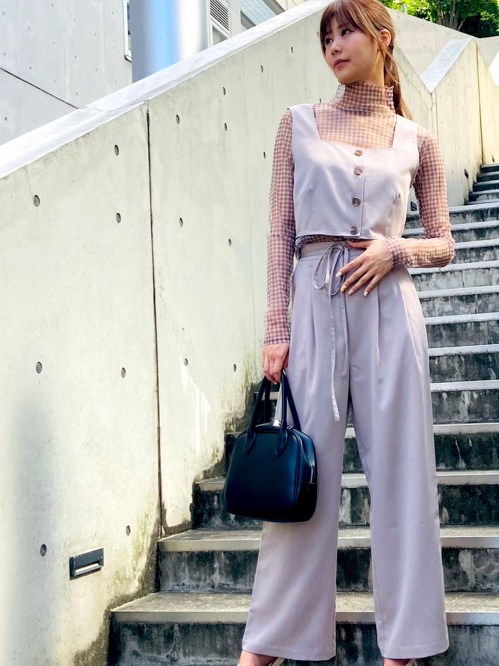 ベージュ系のセットアップ、ブラック系のセットアップを着用したレディースの夏コーディネートの2枚目の写真