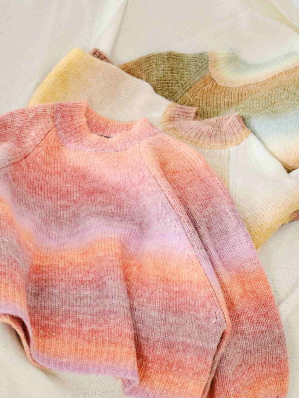 オレンジ系のニット/セーター、ブルー系のデニムパンツを着用したレディースの秋コーディネートの4枚目の写真