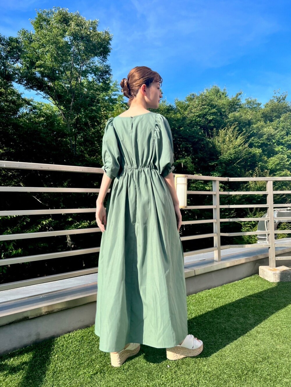 グリーン系のワンピースを着用したレディースの夏コーディネートの2枚目の写真