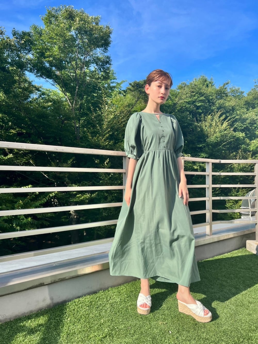 グリーン系のワンピースを着用したレディースの夏コーディネートの3枚目の写真