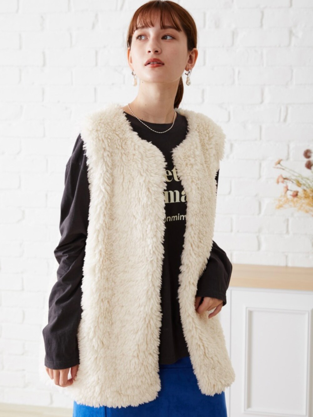 ホワイト系のベストを着用したレディースの夏コーディネートの3枚目の写真