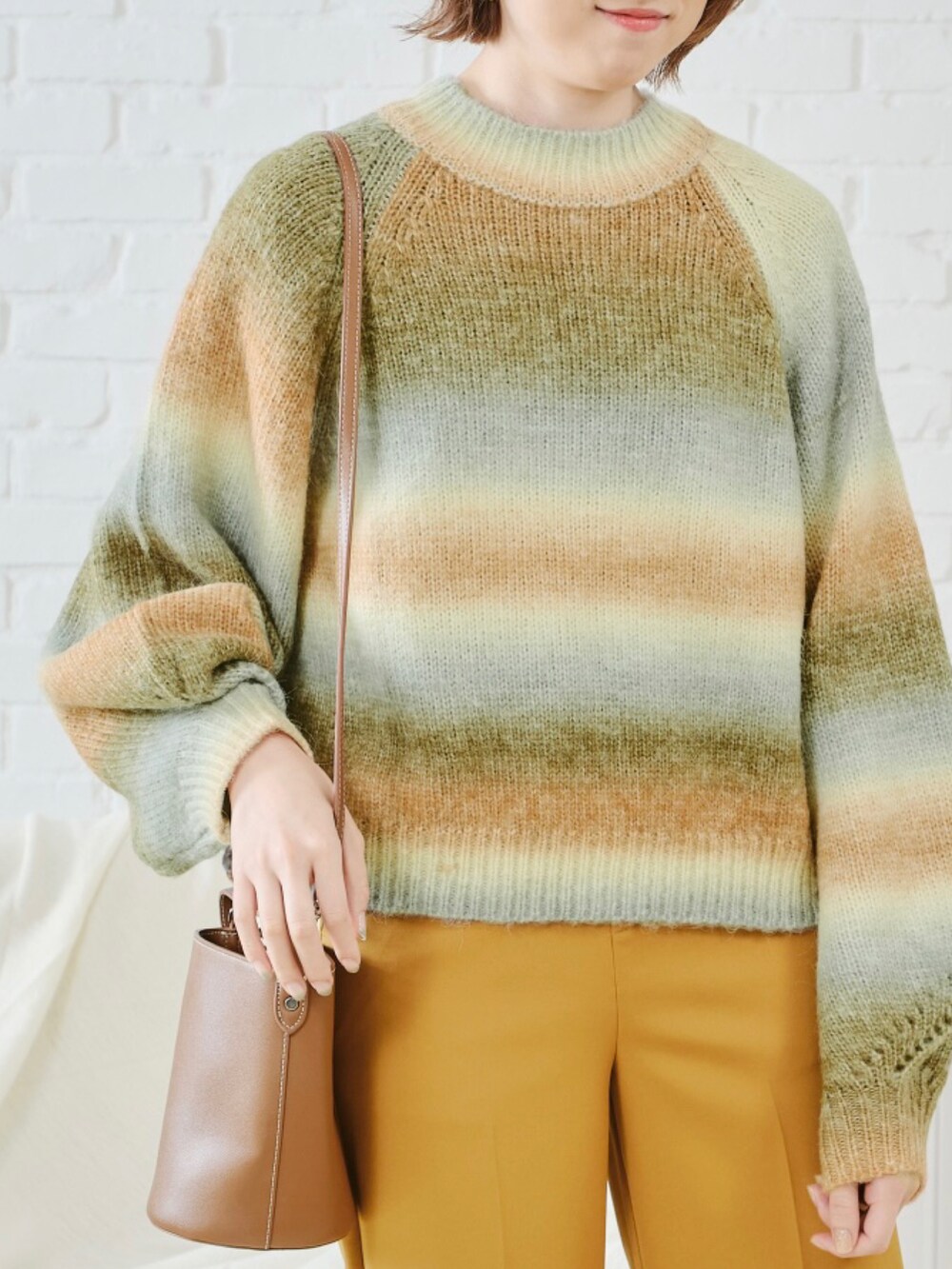 イエロー系のニット/セーターを着用したレディースの秋コーディネートの4枚目の写真