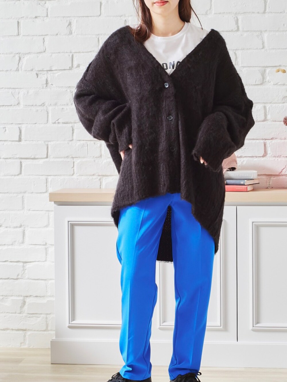 オレンジ系のカーディガン/ボレロ、ブラック系のデニムパンツ、ブラック系のTシャツ/カットソーを着用したレディースの秋コーディネートの4枚目の写真