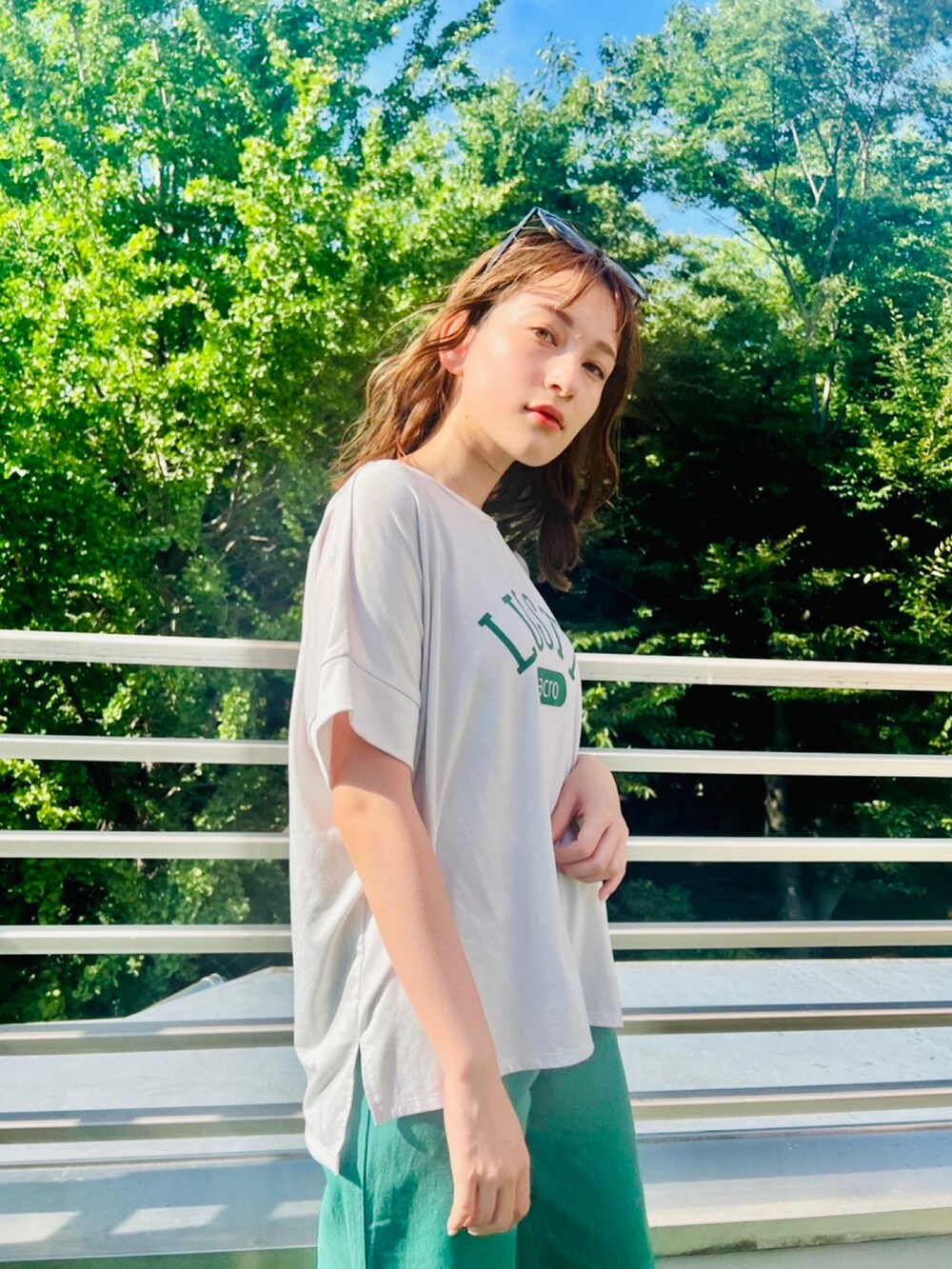 ホワイト系のTシャツ/カットソー、グリーン系のデニムパンツを着用したレディースの夏コーディネートの2枚目の写真