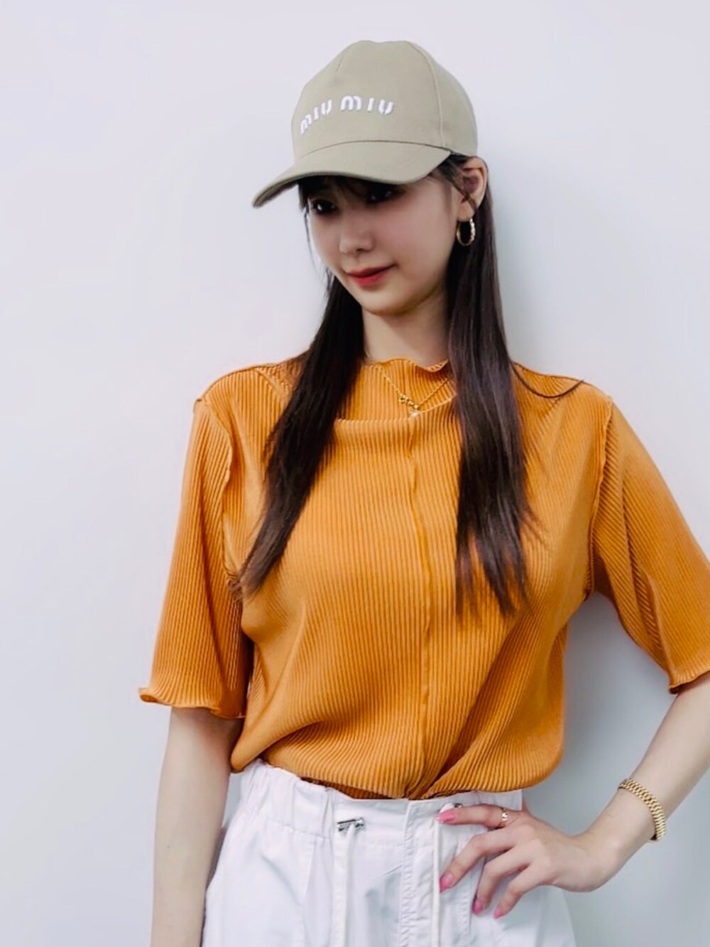 オレンジ系のTシャツ/カットソーを着用したレディースの夏コーディネートの2枚目の写真