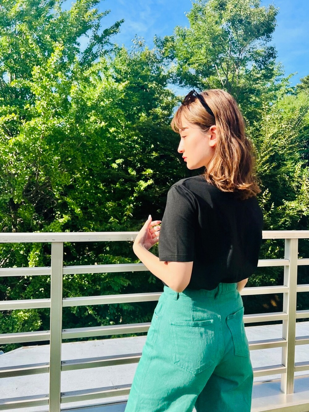 ブラック系のTシャツ/カットソー、グリーン系のデニムパンツを着用したレディースの夏コーディネートの2枚目の写真