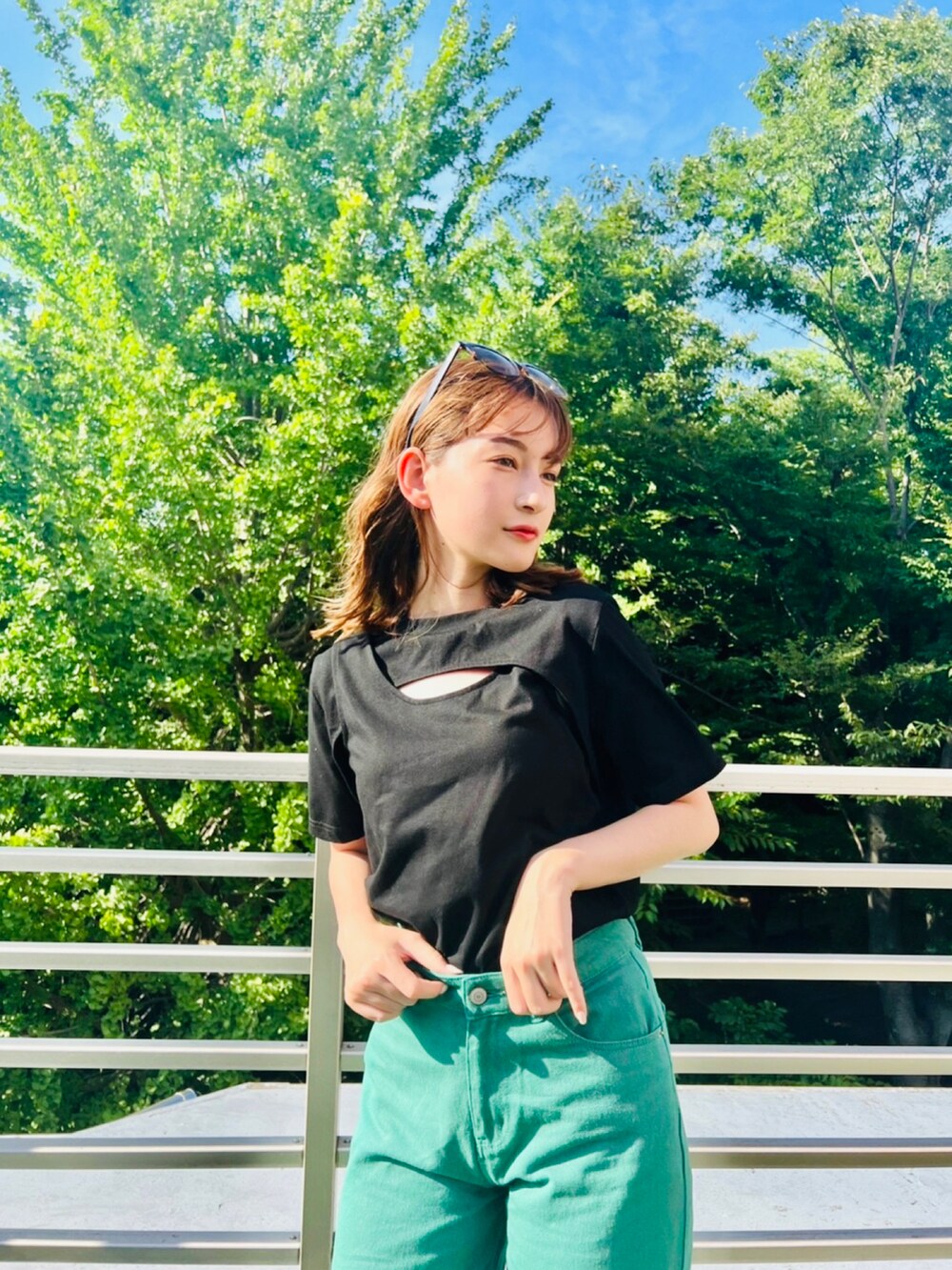 ブラック系のTシャツ/カットソー、グリーン系のデニムパンツを着用したレディースの夏コーディネートの3枚目の写真