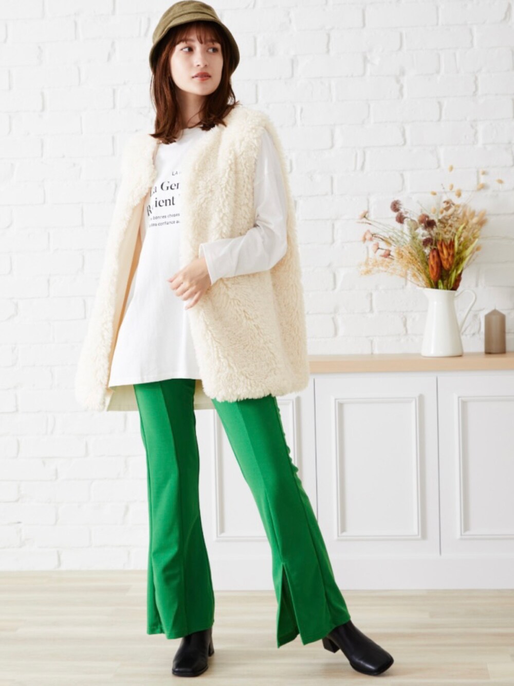 ホワイト系のベストを着用したレディースの夏コーディネートの2枚目の写真