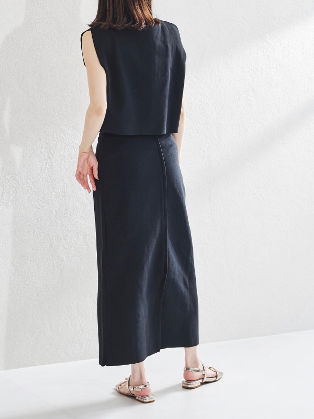 ブラック系のベスト、ブラック系のスカートを着用したレディースの夏コーディネートの2枚目の写真