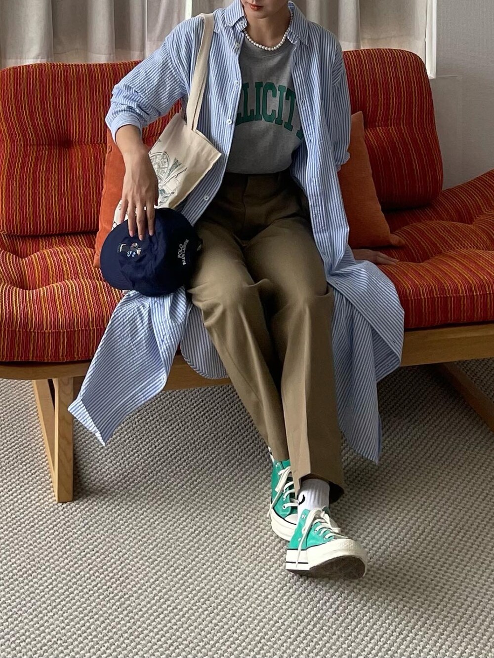 ベージュ系のチノパンツを着用したレディースの夏コーディネートの2枚目の写真