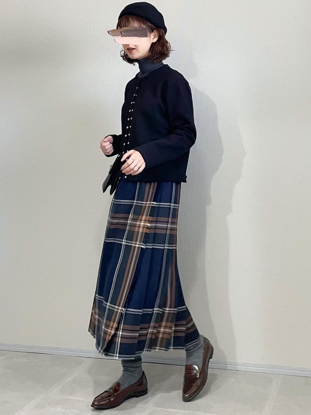 ブラック系のカーディガン/ボレロ、ブラック系のショルダーバッグ、ブルー系のスカートを着用したレディースの秋コーディネートの2枚目の写真