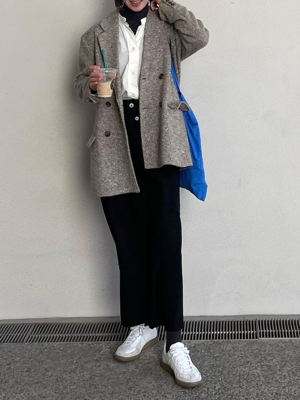 ブラック系のスカート、ホワイト系のスニーカーを着用したレディースの春コーディネートの3枚目の写真