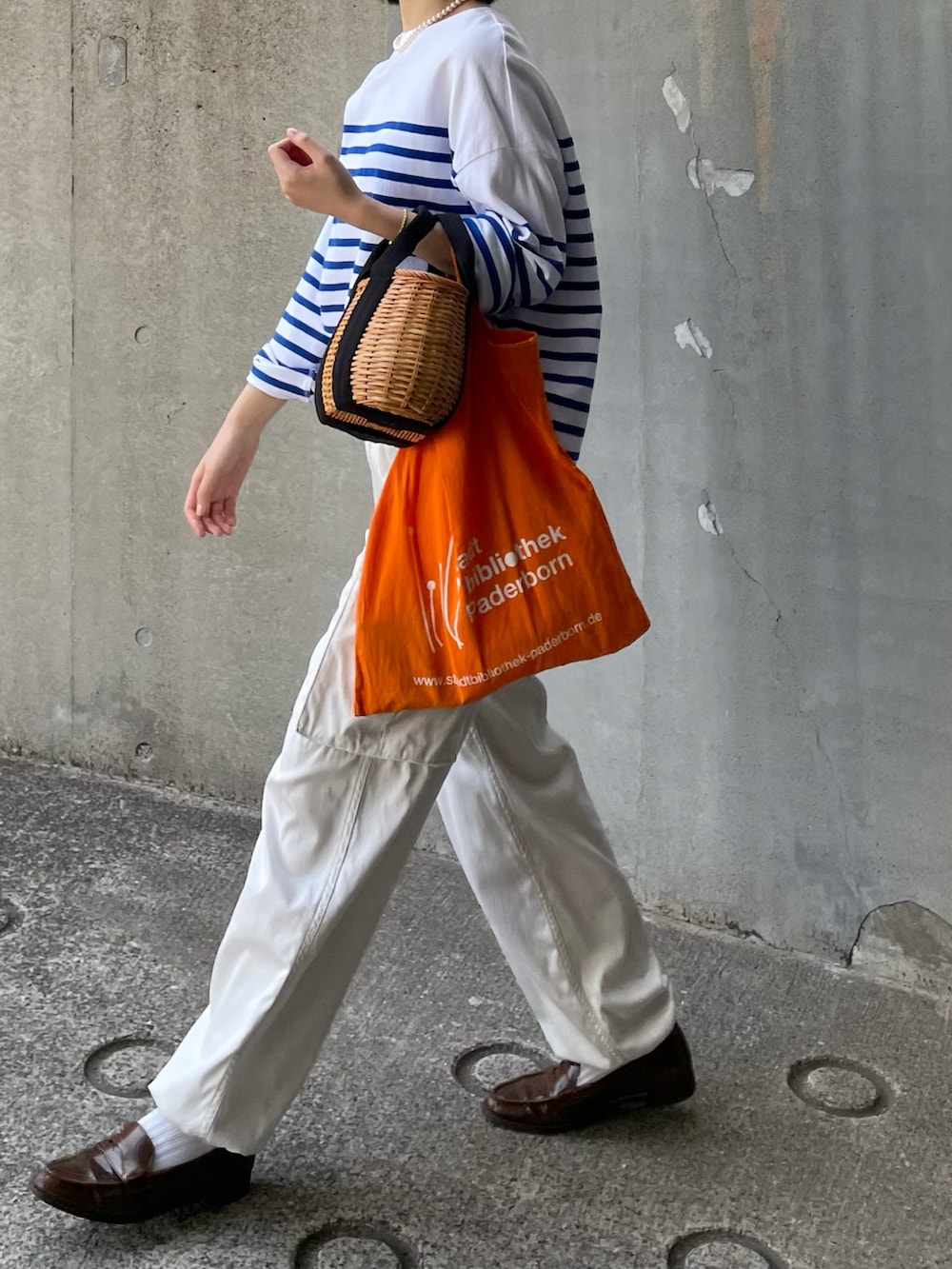 ホワイト系のTシャツ/カットソー、イエロー系のかごバッグ、ホワイト系のカーゴパンツを着用したレディースの春コーディネートの2枚目の写真