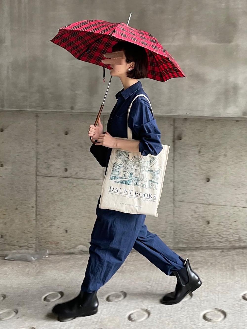 ブラック系のボストンバッグ、ブルー系のTシャツ/カットソー、ブラック系のレインシューズを着用したレディースの春コーディネートの3枚目の写真