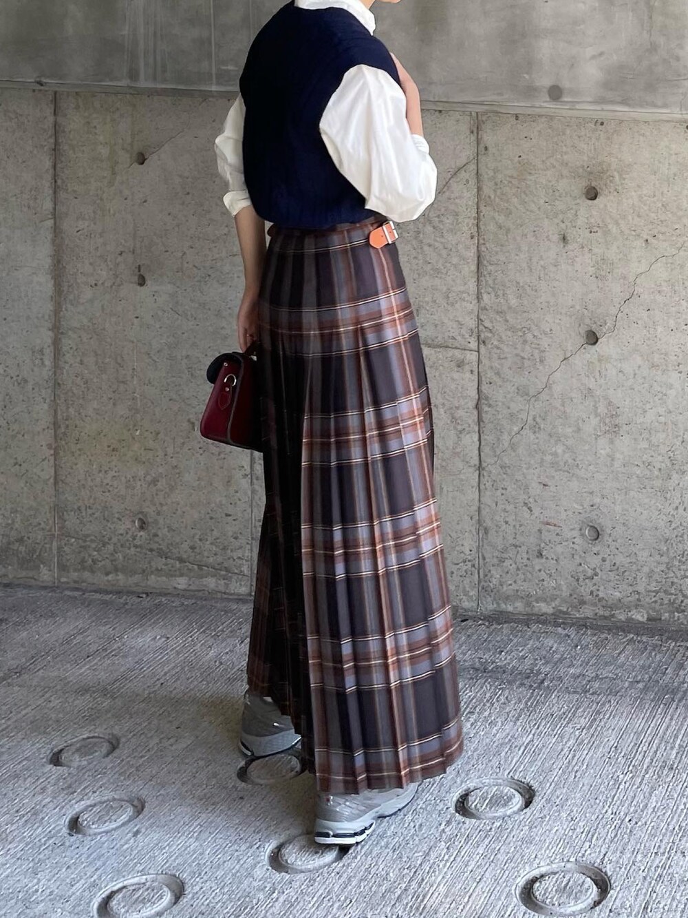 グレー系のスニーカー、ブラウン系のショルダーバッグ、ホワイト系のシャツ/ブラウスを着用したレディースの秋コーディネートの2枚目の写真