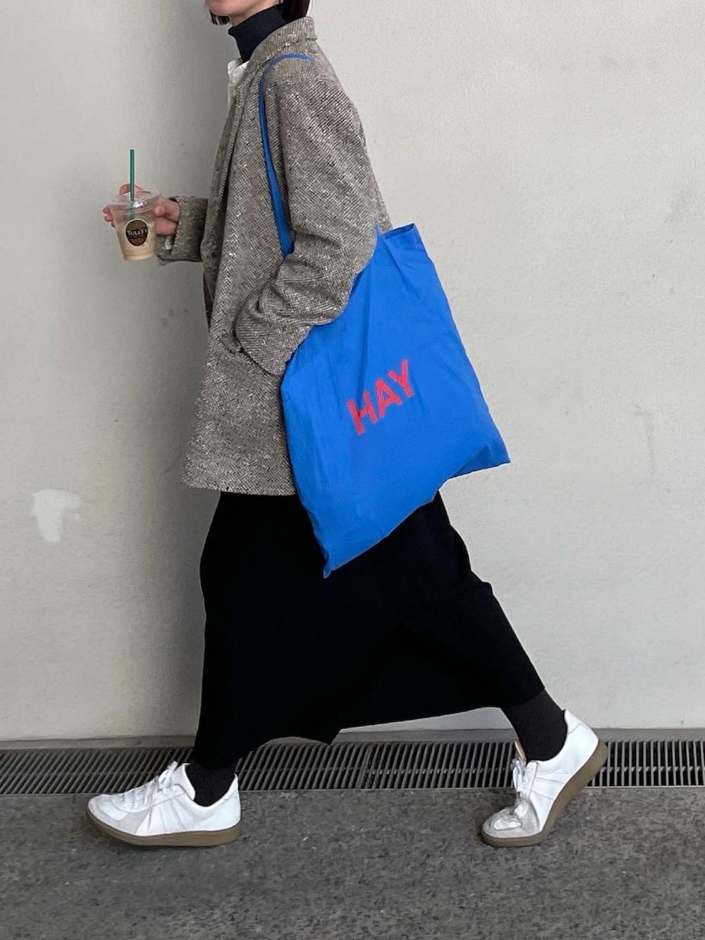 ブラック系のスカート、ホワイト系のスニーカーを着用したレディースの春コーディネートの4枚目の写真