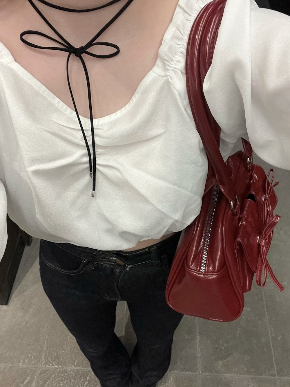 ブルー系のデニムパンツ、レッド系のパンプス、レッド系のハンドバッグを着用したレディースの春コーディネートの2枚目の写真