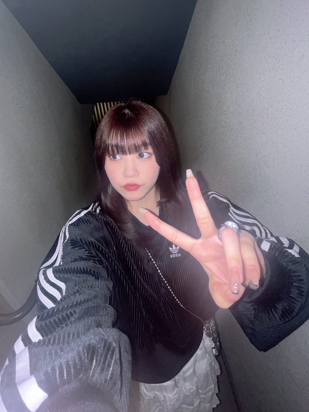 ブラウン系のバッグ、ホワイト系のスカート、その他のデニムパンツを着用したレディースの秋コーディネートの2枚目の写真