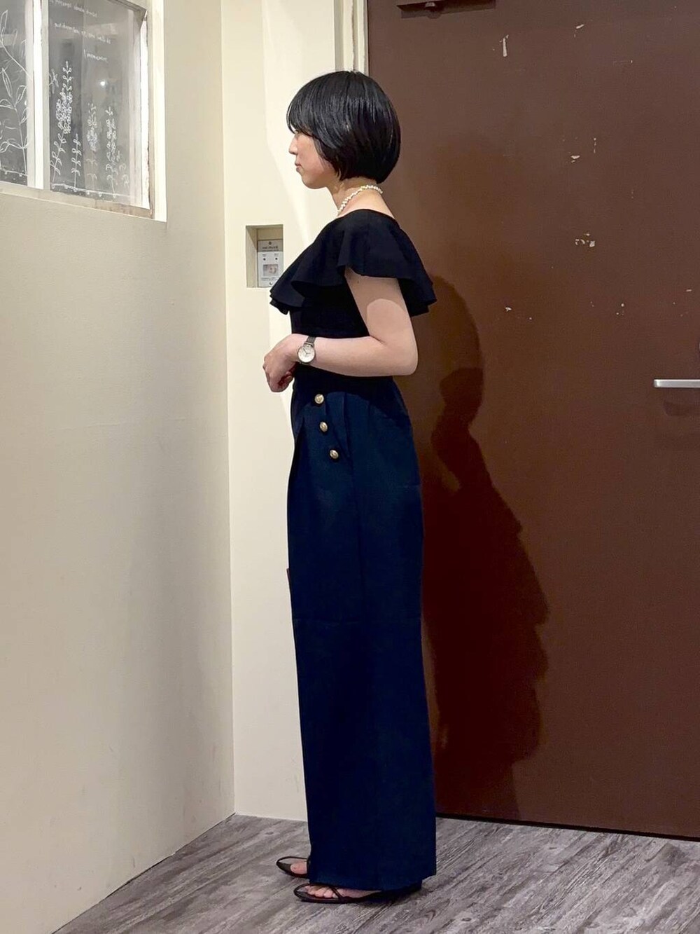 ブラック系のニット/セーター、ブルー系のその他パンツ、ホワイト系のネックレスを着用したレディースの春コーディネートの3枚目の写真