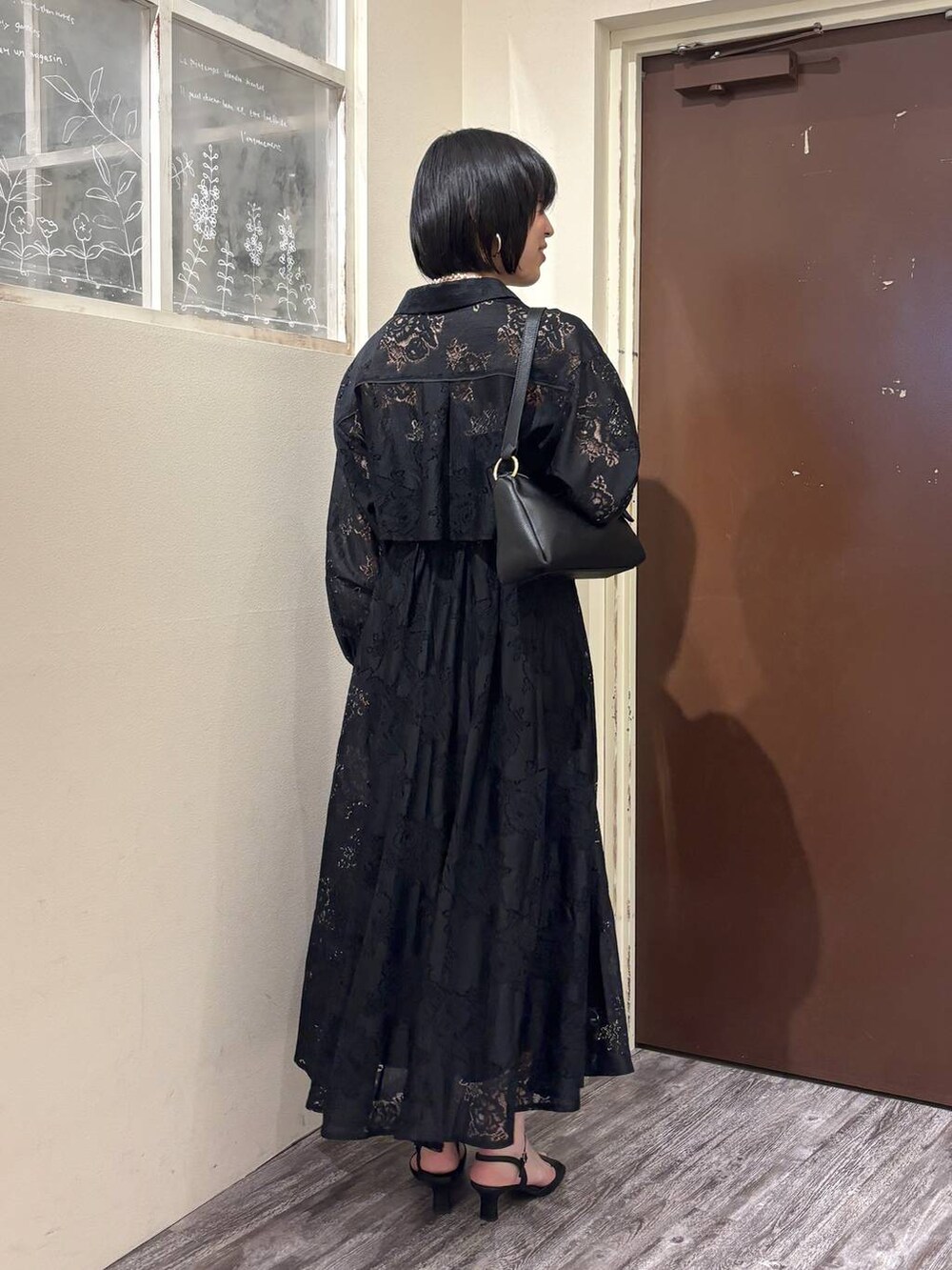 ブラック系のワンピース、ブラック系のショルダーバッグ、ブラック系のサンダルを着用したレディースの春コーディネートの3枚目の写真
