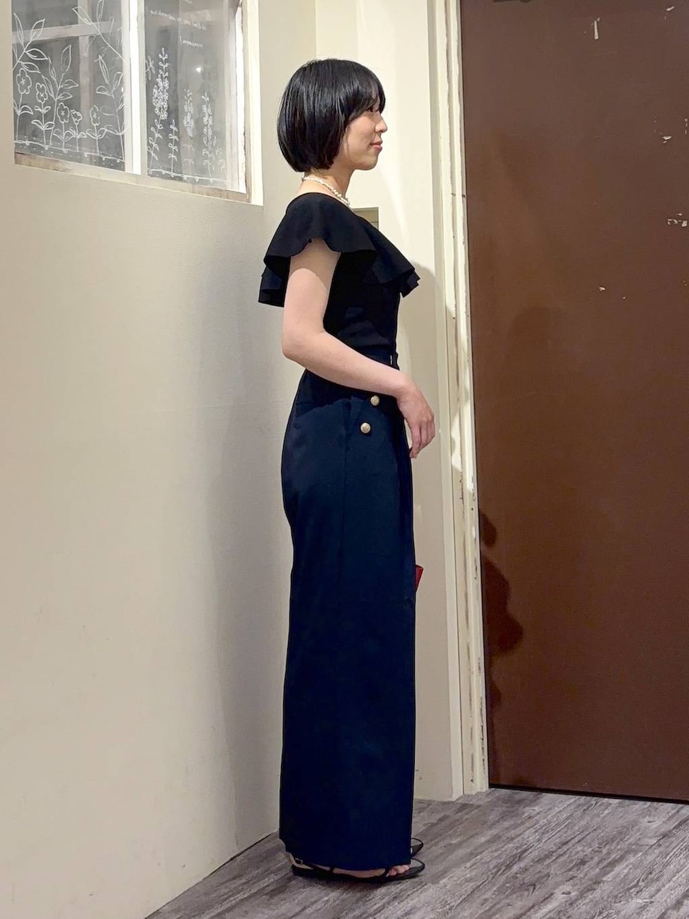 ブラック系のニット/セーター、ブルー系のその他パンツ、ホワイト系のネックレスを着用したレディースの春コーディネートの5枚目の写真