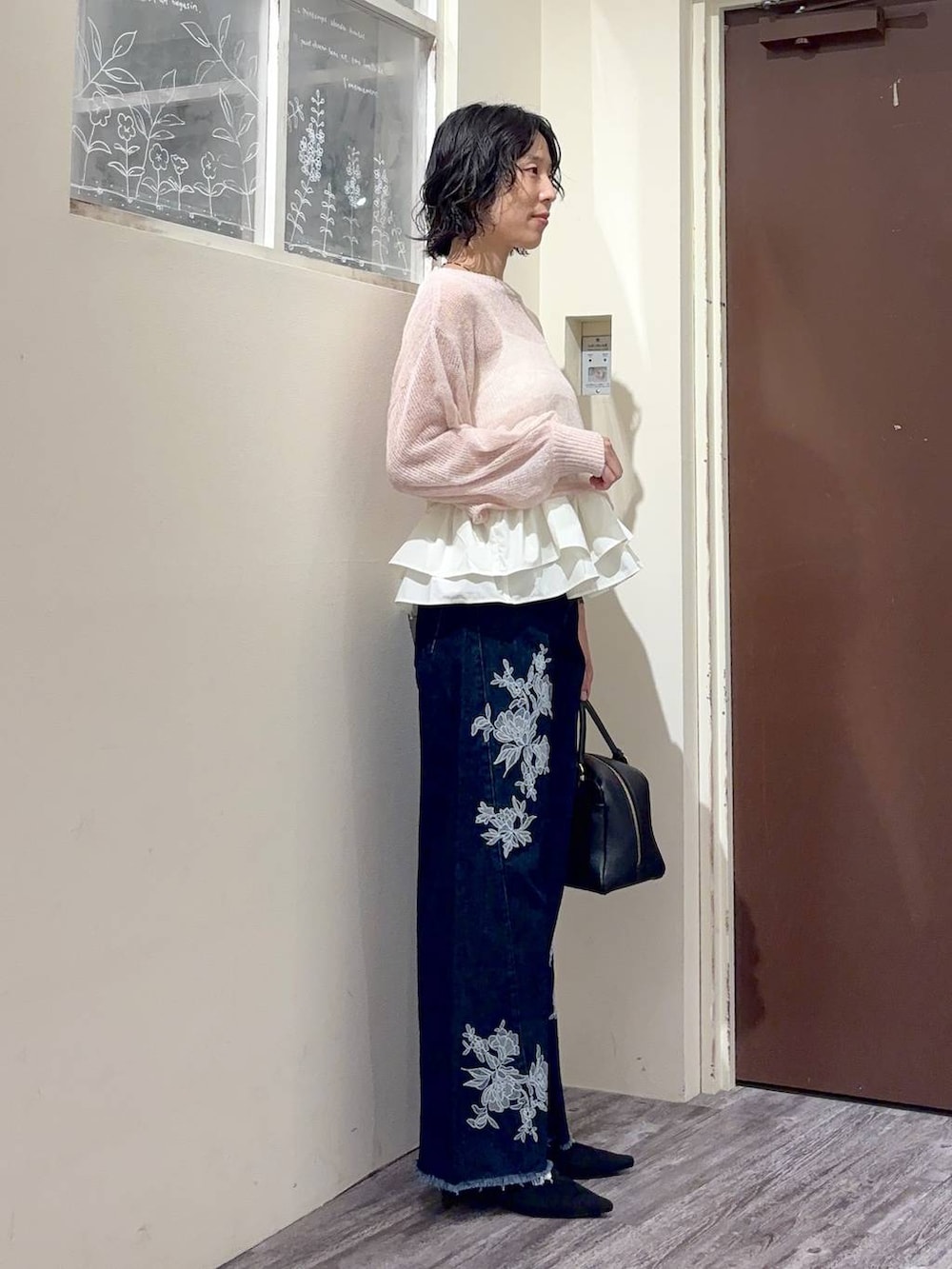 ブラック系のサンダル、ブルー系のデニムパンツ、ピンク系のニット/セーターを着用したレディースの秋コーディネートの2枚目の写真