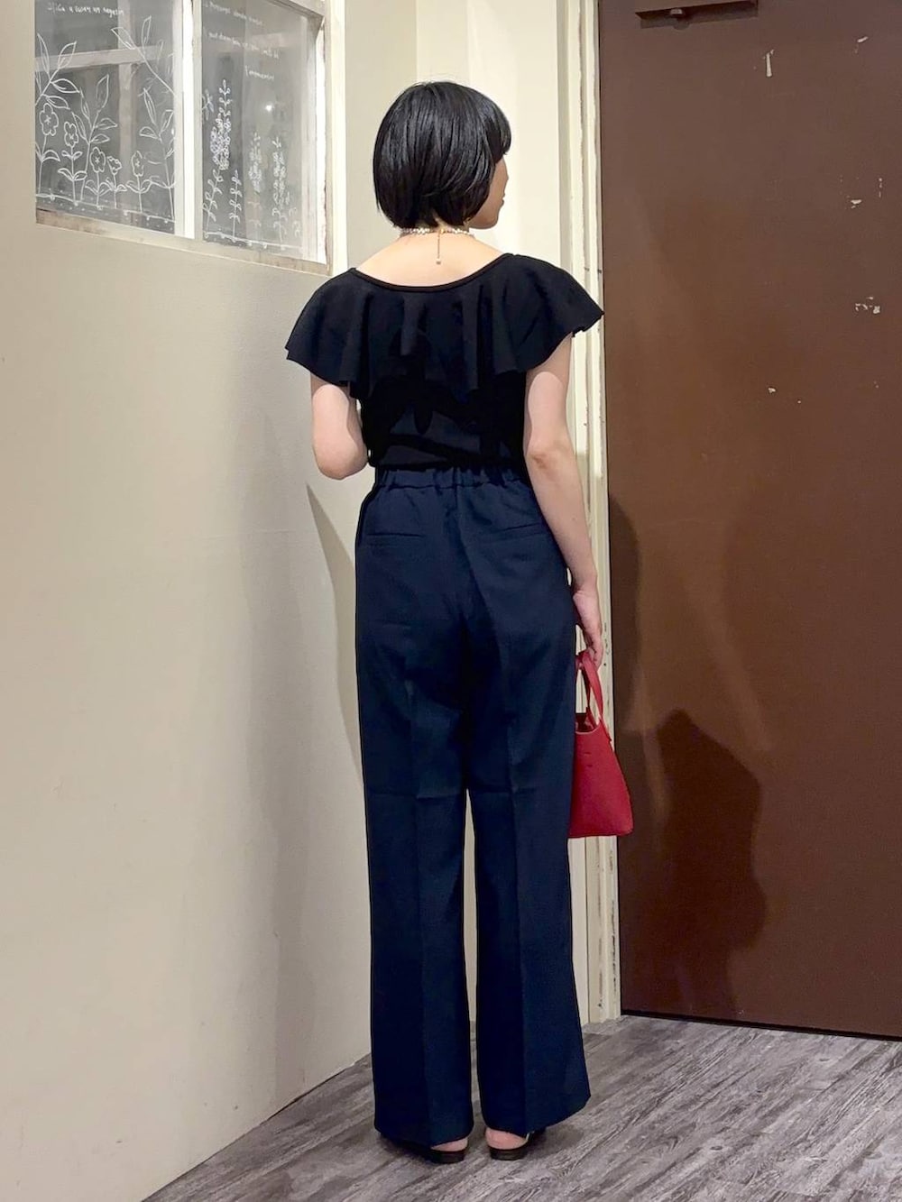 ブラック系のニット/セーター、ブルー系のその他パンツ、ホワイト系のネックレスを着用したレディースの春コーディネートの4枚目の写真