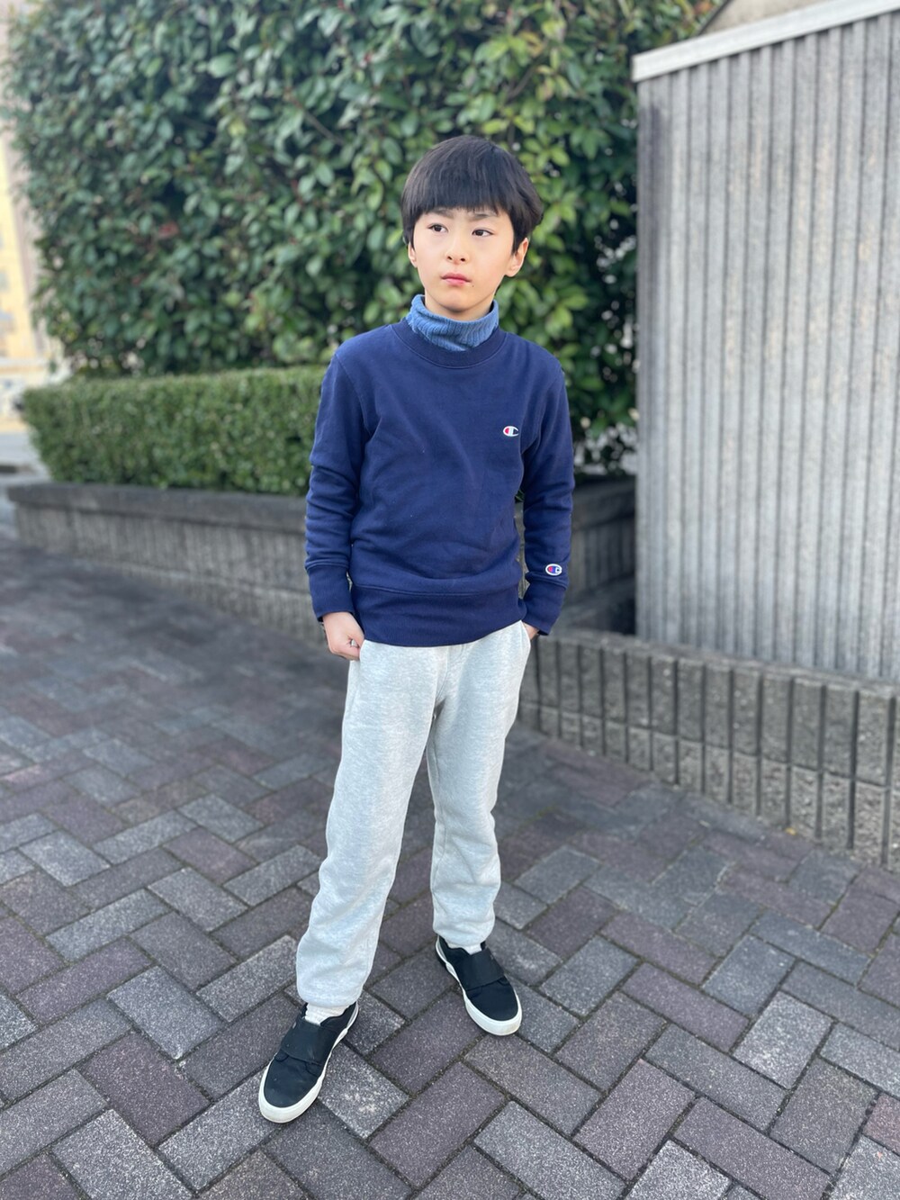 グレー系のスウェットパンツ、ブルー系のスウェット、ブラック系のスリッポンを着用したキッズの春コーディネートの4枚目の写真