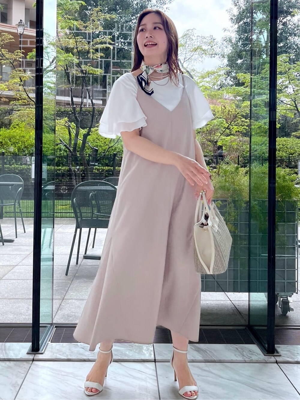 ベージュ系のワンピース、ホワイト系のTシャツ/カットソーを着用したレディースの夏コーディネートの2枚目の写真