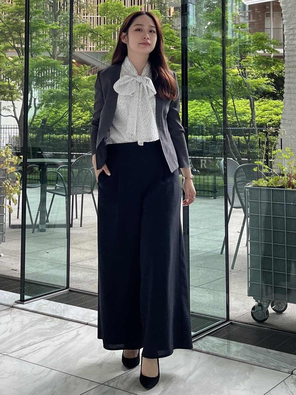 ブラック系のその他パンツ、ホワイト系のシャツ/ブラウス、ブルー系のノーカラージャケットを着用したレディースの春コーディネートの2枚目の写真