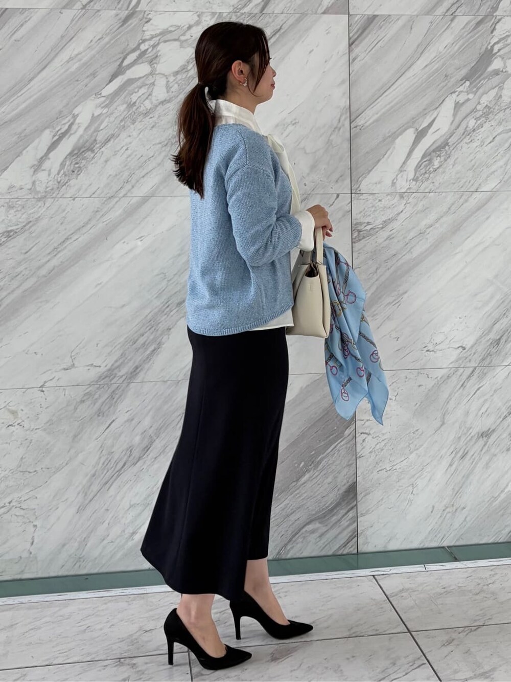 ブルー系のニット/セーター、ホワイト系のシャツ/ブラウス、ブルー系のスカートを着用したレディースの春コーディネートの4枚目の写真